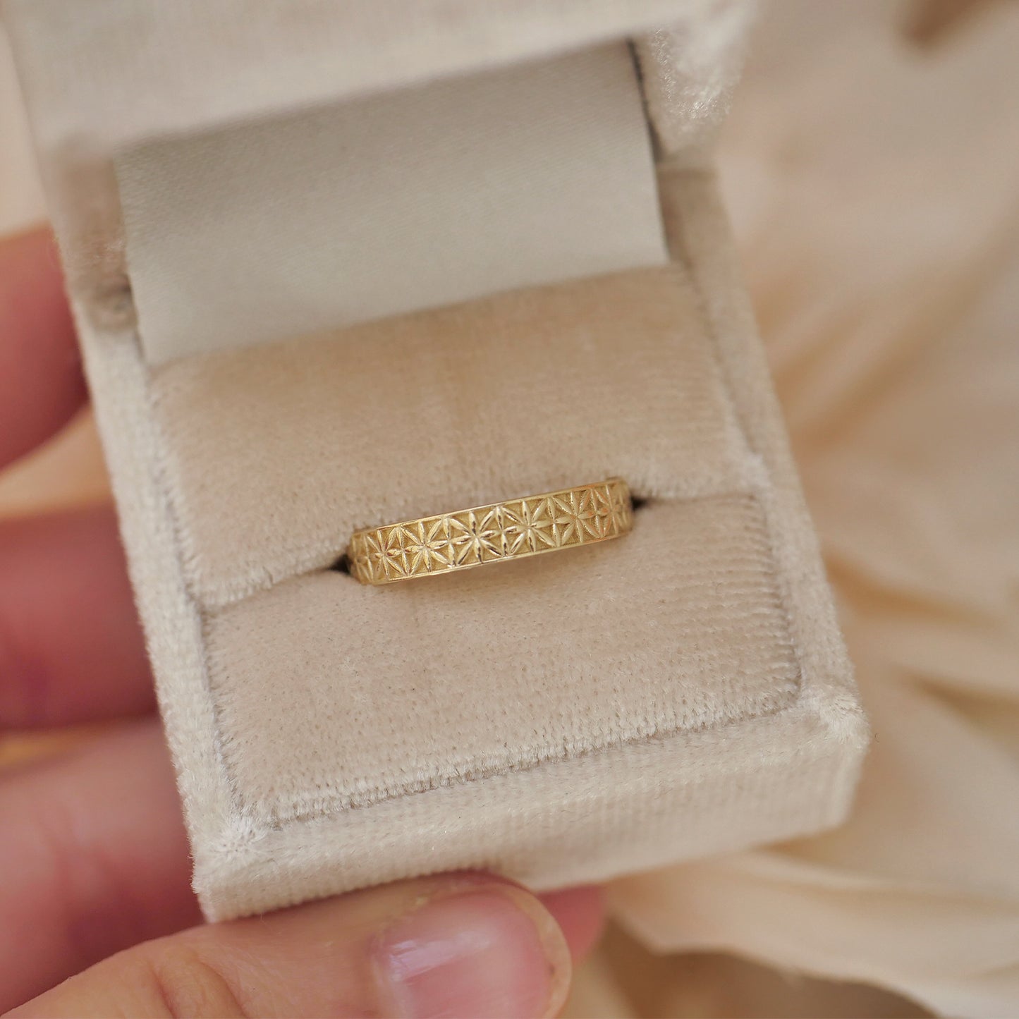 Woman holding velvet ring box featuring vintage vintage-inspired antique star band.