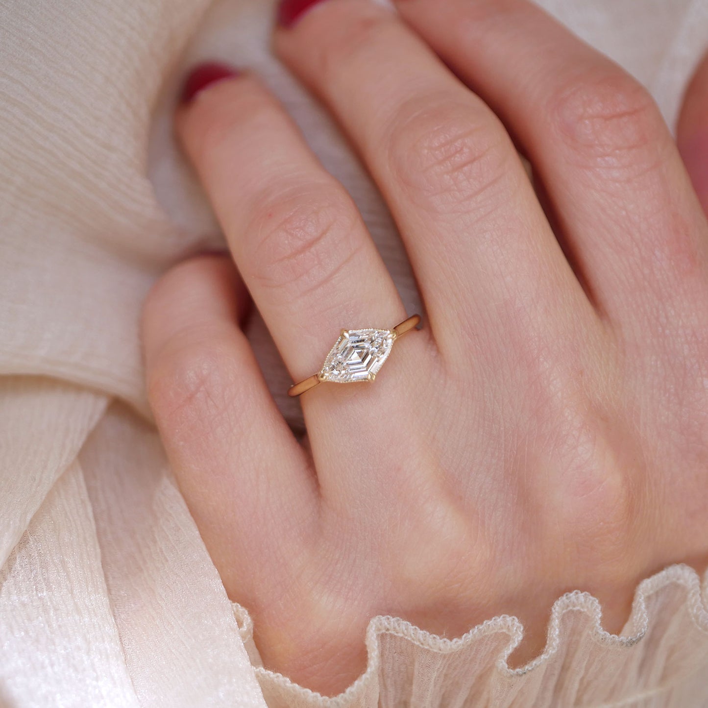 A striking lozenge cut diamond at the heart of this engagement ring creating a luxurious and cohesive bridal set.