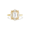 A gold ring featuring a colorless emerald cut moissanite center stone with natural round brilliant diamonds around it.