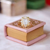 Petal-like 14k yellow gold engraved frame the center diamond, giving the ring a soft, nature-inspired charm.