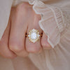 Woman wearing ruffle top with deco inspired diamond engagement ring.