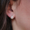 Close-up of an ear wearing a cobblestone huggie diamond earrings.