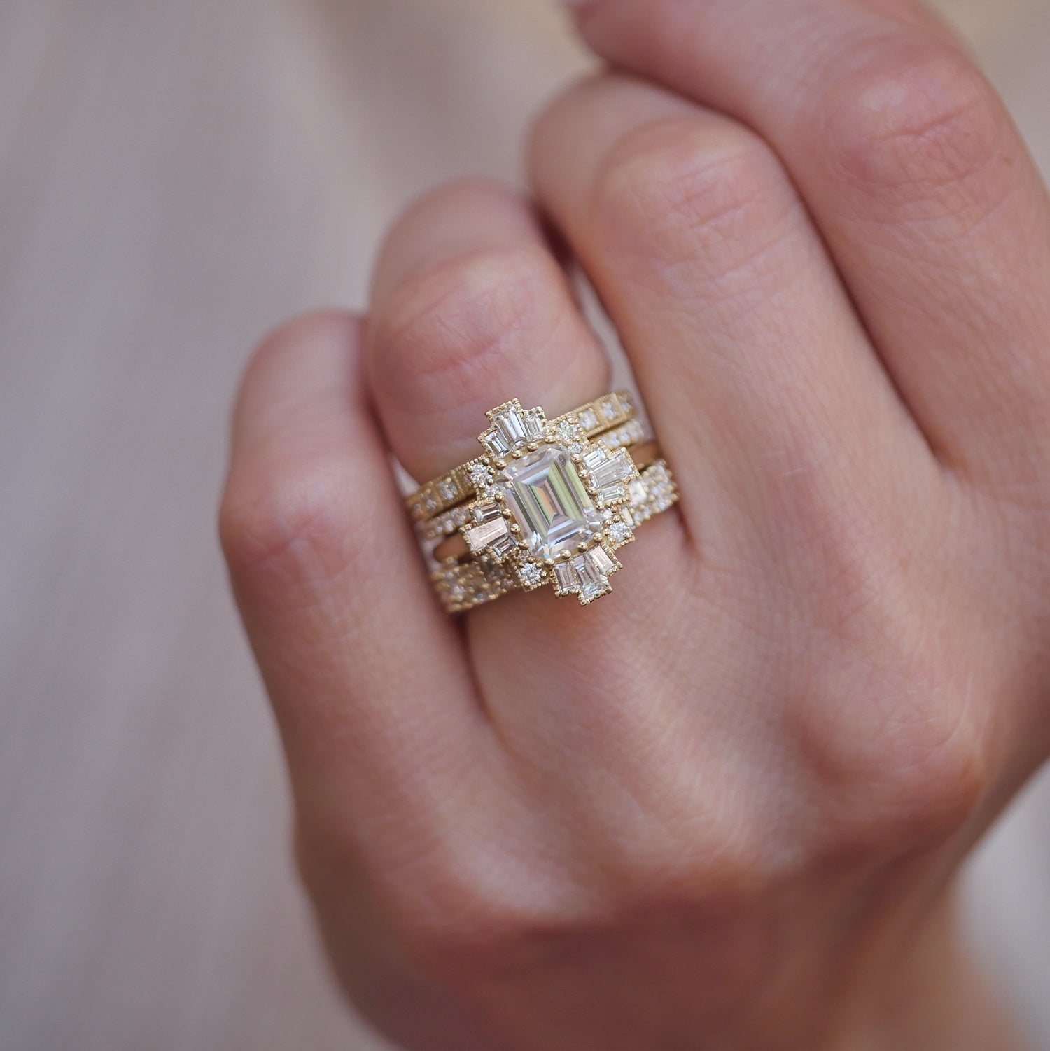 woman wearing a collection of vintage inspired engagement ring stacked with natural deco diamond wedding bands