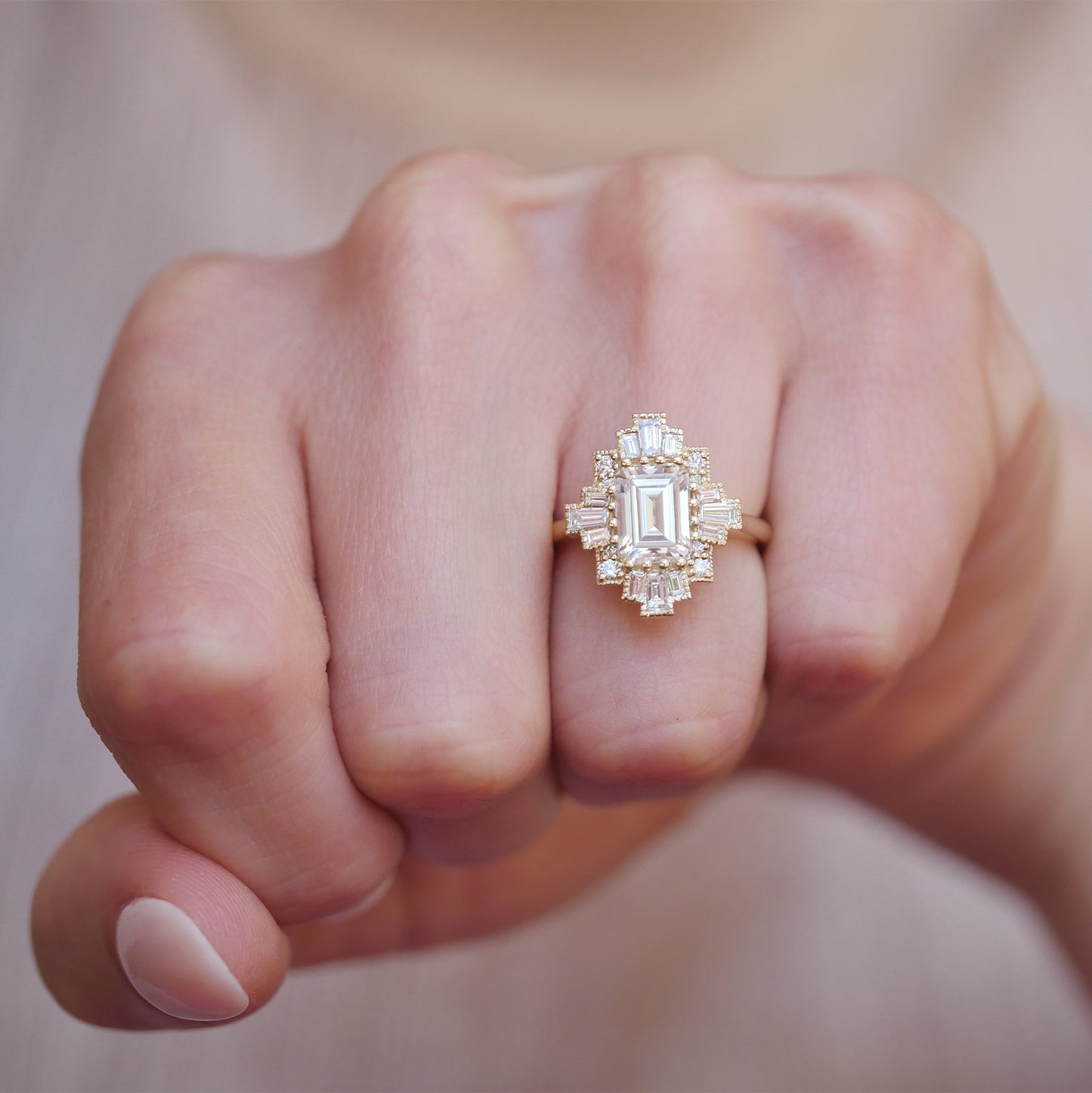 woman wearing 14k yellow gold deco moissanite and diamond engagement ring