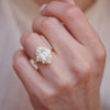 A woman wearing a unique 14k yellow gold deco moissanite and diamond engagement ring perfect for stacking.