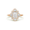 A deco moissanite and diamond engagement ring set in 14k rose gold.
