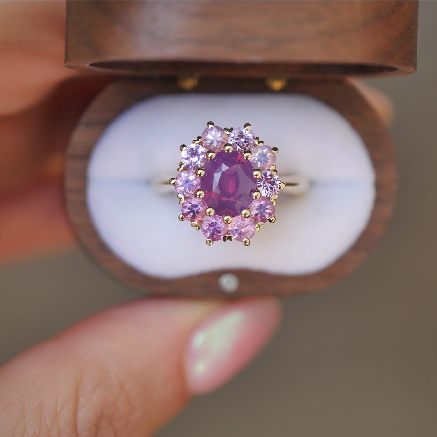 woman holding vintage wooden box with a one of a kind vintage inspired cluster ring with purple and pink sapphires