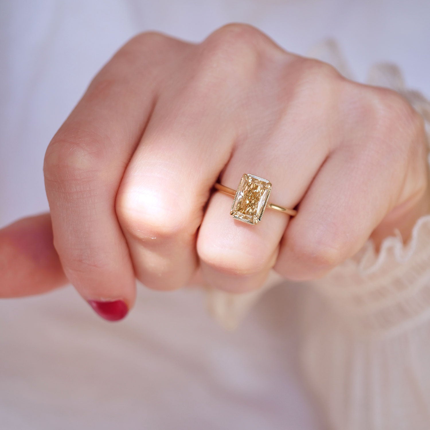 woman wearing emerald cut radiant cut engagement ring