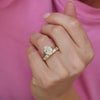 This split shank engagement ring, designed with oval brilliant cut diamonds, is paired with perfectly contoured diamond wedding bands, creating an exquisite and refined bridal set full of elegance and sparkle.