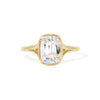 An elongated antique cushion cut solitaire ring with a lab-grown diamond and milgrain detailing on a yellow gold band.