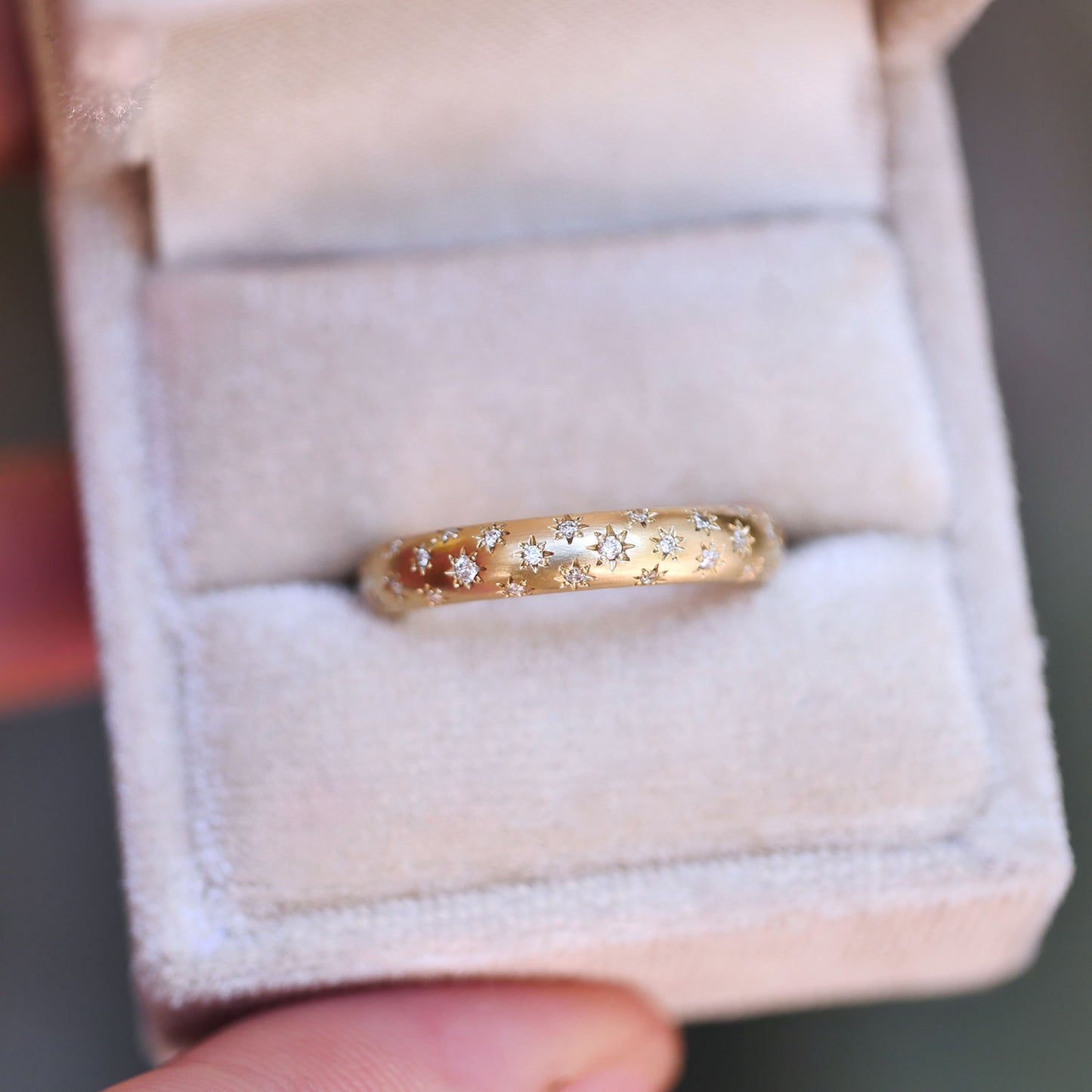 star engraved ring with embedded diamonds in a ring box