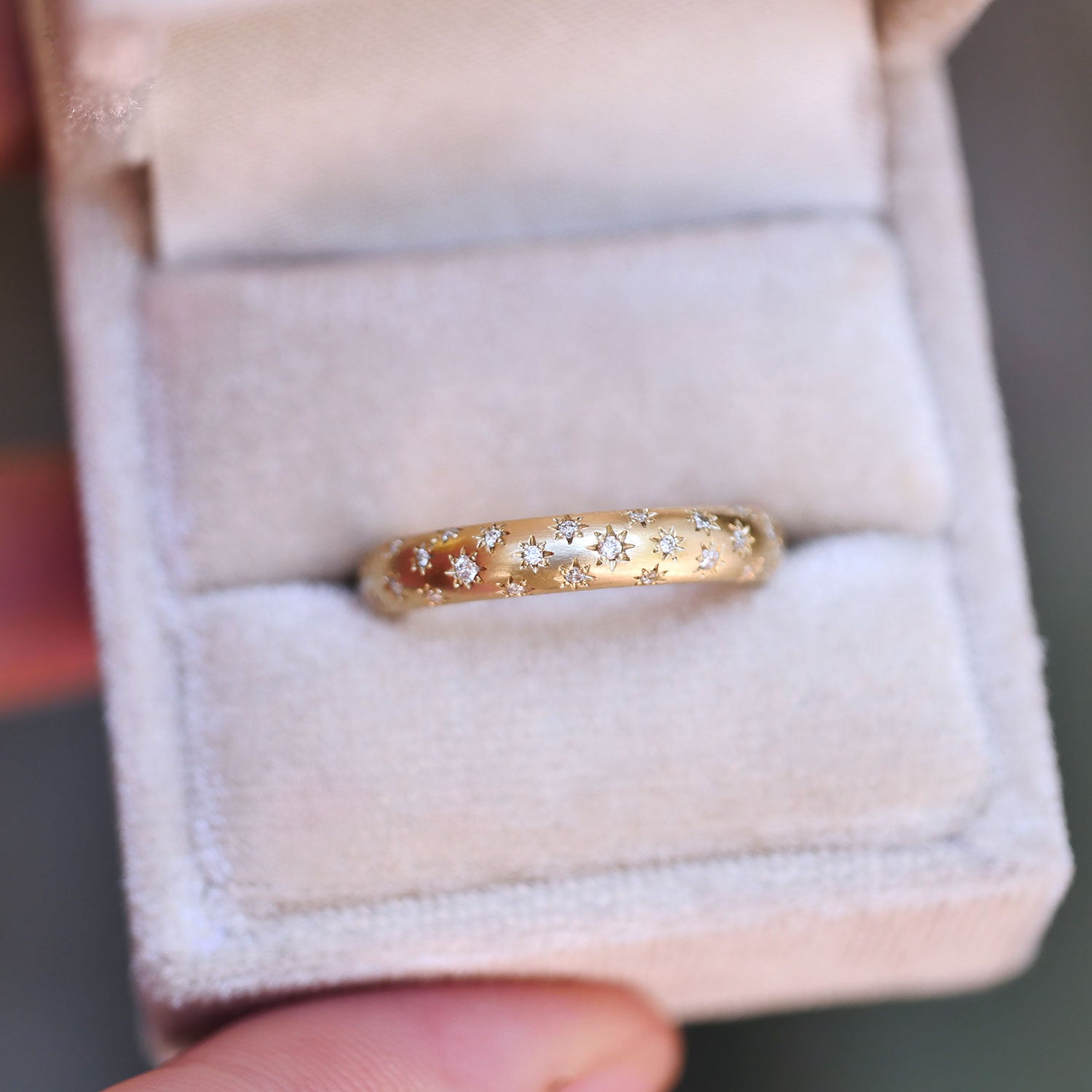 star engraved ring with embedded diamonds in a ring box