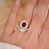 A woman wearing a ruby and diamond engagement ring with a cobblestone diamond contour ring.