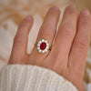 A woman wearing a ruby and diamond engagement ring.