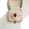 Vintage-inspired ruby and diamond engagement ring in a velvet ring box.