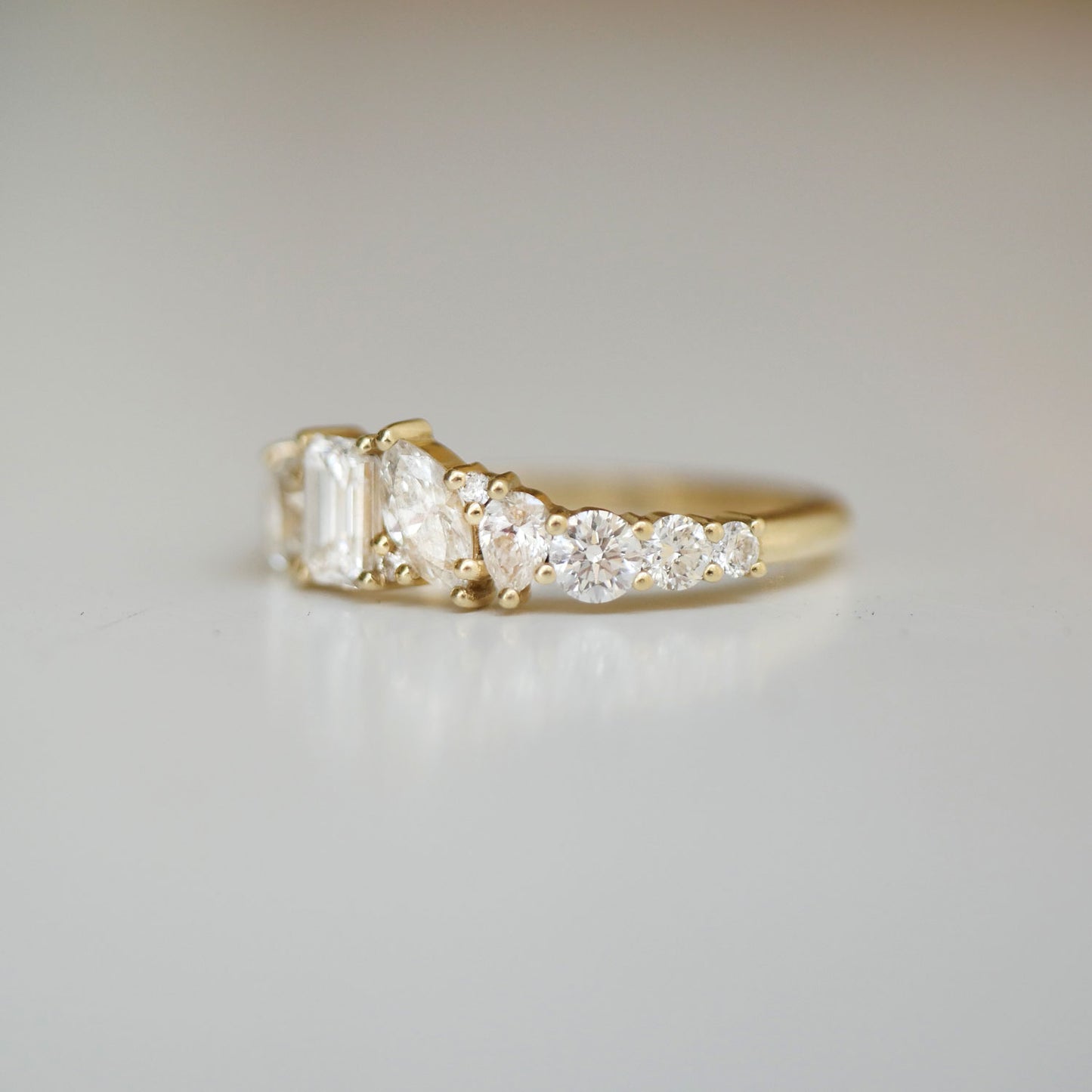 The Emerald & Marquise Firework Diamond Mosaic Band exudes timeless elegance, with emerald and marquise diamonds set in a stunning arrangement that sparkles like a fireworks display.