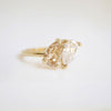 The soft, golden hue of the pear-shaped champagne diamond adds a touch of sophistication, making this ring a unique and timeless expression of love and devotion.