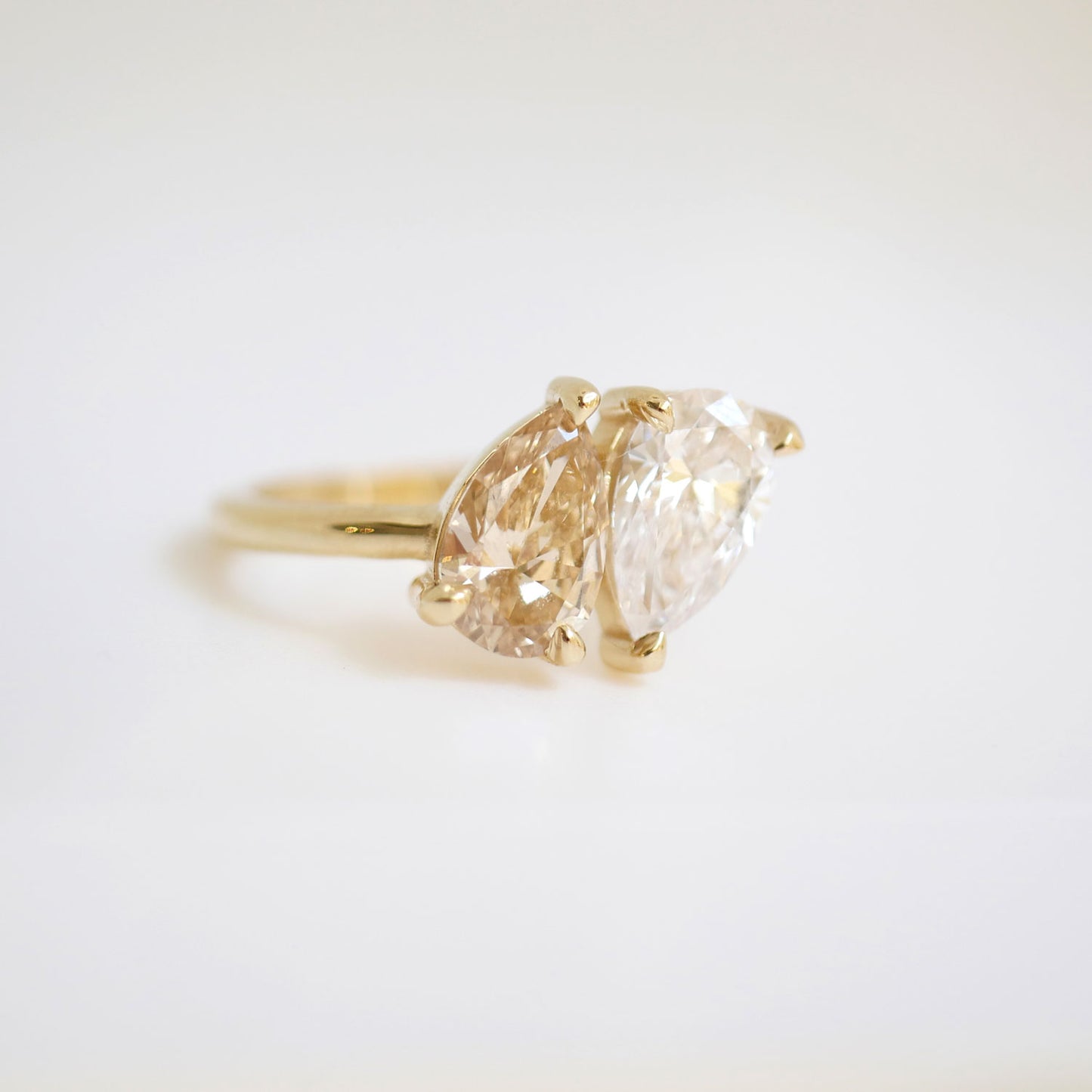 The soft, golden hue of the pear-shaped champagne diamond adds a touch of sophistication, making this ring a unique and timeless expression of love and devotion.