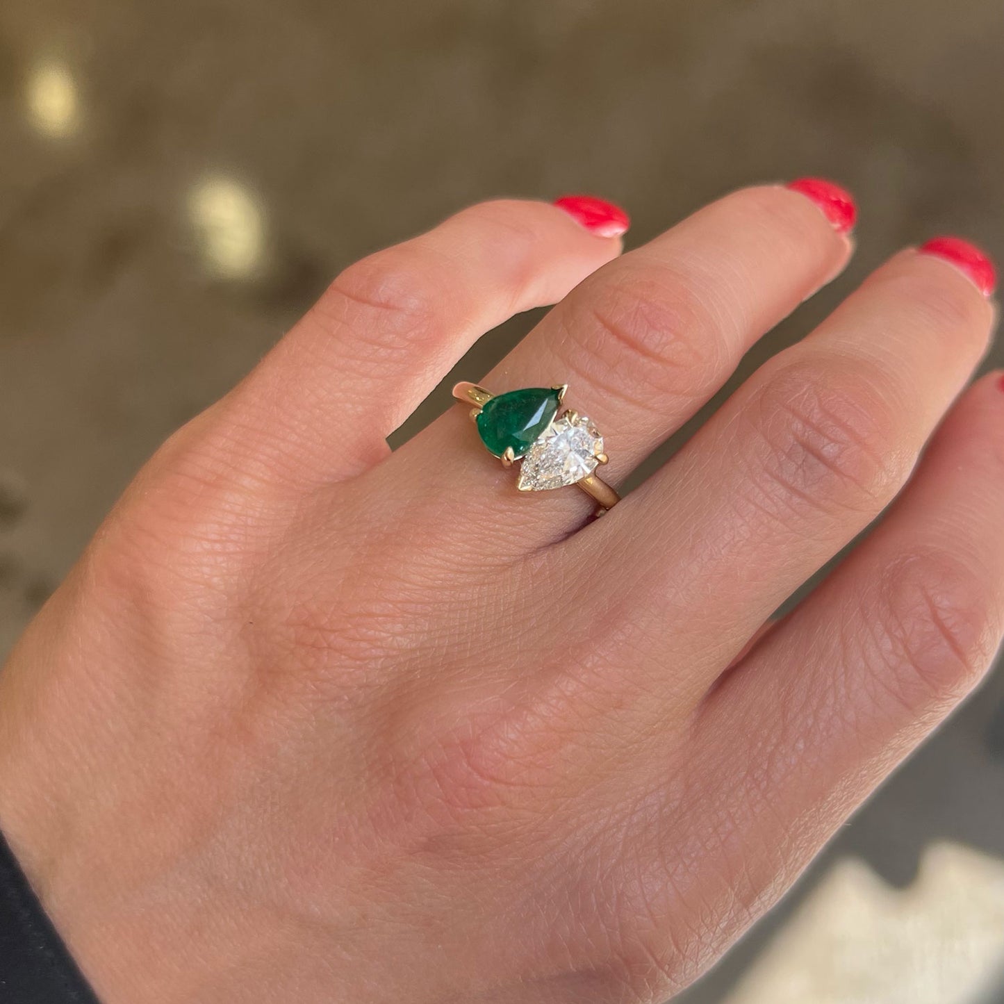 The pear-shaped emerald, symbolizing growth and renewal, beautifully complements the diamond’s brilliance, making this ring a meaningful and stunning expression of love.